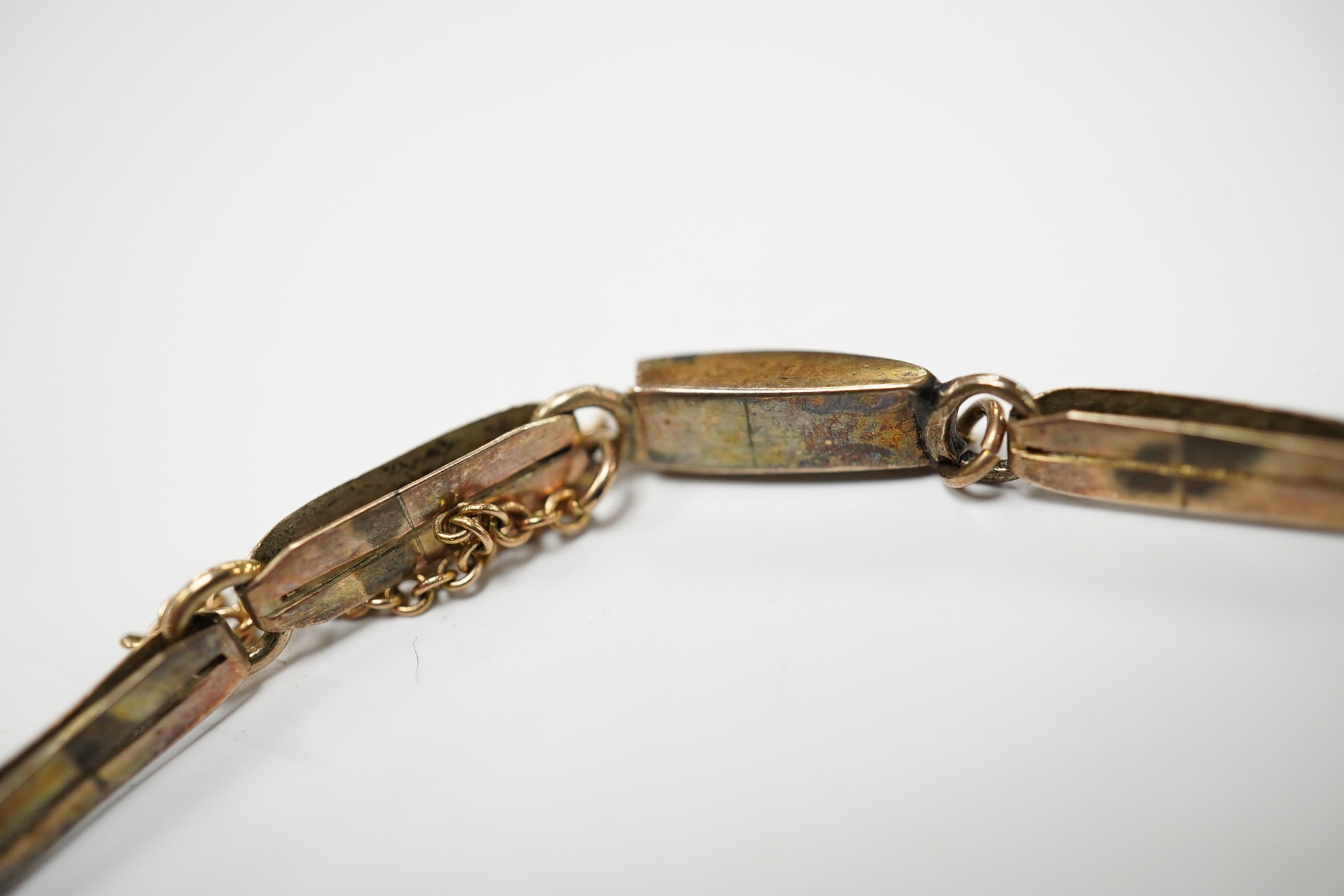 A 19th century engraved yellow metal and two colour paste set bracelet, with safety chain, gross weight 10.1 grams. Condition - fair